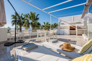 a patio with white furniture and a table and chairs at Solaga - Miguel in Málaga