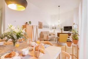 a living room with a table with bread on it at Solaga - Larios Suites in M&aacute;laga