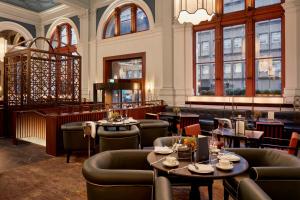 um restaurante com mesas, cadeiras e janelas em The Parkgate Hotel em Cardiff