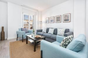 マラガにあるSolaga - Suites Mercedのリビングルーム(青いソファ、テーブル付)