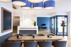 une salle à manger avec des murs bleus, une table et des chaises dans l'établissement VISIONAPARTMENTS Geneva Gare, à Genève