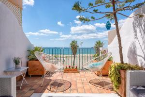 taras z krzesłami i widokiem na ocean w obiekcie Noemi Playa Beach House in Malaga by Solaga Holiday Homes w Maladze