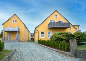 zwei gelbe Häuser auf einer Kopfsteinpflasterstraße in der Unterkunft FeWo 04 im Carré Charlott in Pulsnitz
