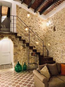 a living room with a staircase and a couch at O'scià Loft in Noto