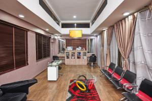 uma sala de espera com cadeiras, uma mesa e uma secretária em Oak Haven Hotel & Suites em Port Harcourt