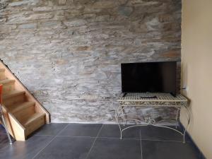 a computer sitting on a table in front of a stone wall at Gîte de charme Rosardenne in Vaux-sur-Sûre