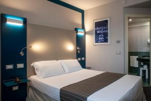 A bed or beds in a room at La Meridiana Bleisure Hotel