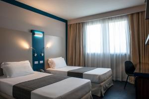 a hotel room with two beds and a window at Hotel La Meridiana in Perugia