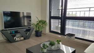 a living room with a flat screen tv and two windows at Azzurro-Top floor apartment in quiet neighborhood, Free private parking in Varna City