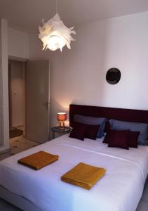 1 dormitorio con 1 cama blanca grande y 2 toallas en LAU 08 Appart Agdal 80m2, en Rabat