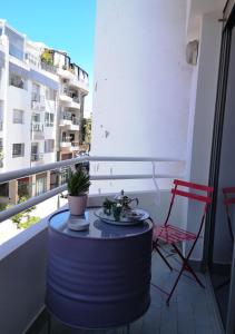 a table and chairs on a balcony with a view of a building at LAU 08 Appart Agdal 80m2 in Rabat