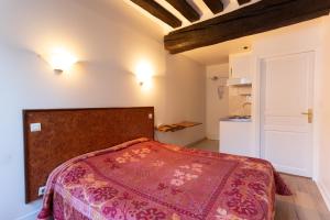 a bedroom with a bed with a red bedspread at Résidence de Bourgogne in Paris