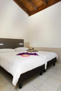Schlafzimmer mit einem großen weißen Bett und einer Holzdecke in der Unterkunft Residence Maroadi in Nago-Torbole