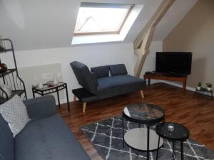 uma sala de estar com um sofá e uma televisão em chambres d'hôtes près de FECAMP em Ganzeville