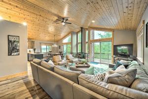 a living room with a large couch and a television at Luxe Truckee Cabin with Golf Course View and Deck in Truckee