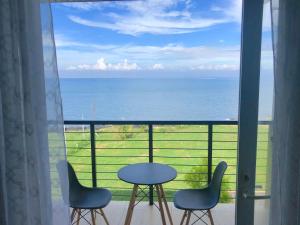 uma vista para o oceano a partir de uma varanda com uma mesa e cadeiras em Acapulco Resort em Toledo City