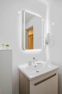 y baño con lavabo blanco y espejo. en Bella Villa en Vrnjačka Banja