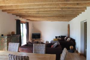 a living room with couches and a tv at La Bastide in Lagrange