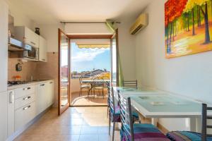 a kitchen with a table and a view of a balcony at Adriatico apartment in Alghero