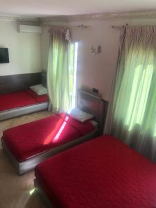 a bedroom with two beds and a red curtain at SINGAPOUR MAROC in Casablanca