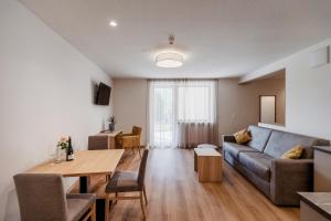 uma sala de estar com um sofá e uma mesa em Margun - Apartments & PanoramaRooms em Malles Venosta