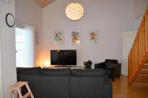 a living room with a couch and a flat screen tv at Apartment Vuokatin Taika 1 - Loppusiivous sisältyy hintaan in Vuokatti
