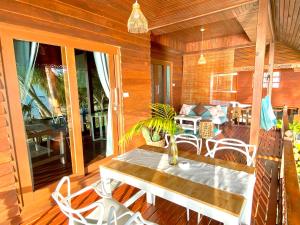 a wooden porch with a table and chairs on a deck at Hin Kong Sunset Beach Front House in Srithanu