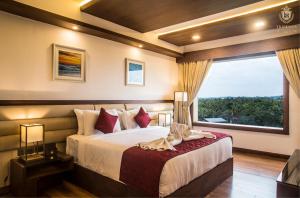a bedroom with a bed and a large window at KPM TRIPENTA HOTEL in Kozhikode +34 photos