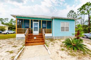 uma casa azul com um alpendre de madeira em Down the Shore em Gulf Shores