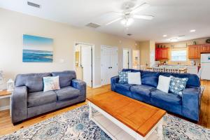 uma sala de estar com um sofá azul e uma mesa em Down the Shore em Gulf Shores