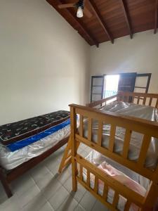 卡拉瓜塔圖巴的住宿－CASA DE PRAIA CARAGUA com PISCINA Acomoda 15 Pessoas，一间卧室设有两张双层床和天花板