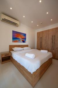 1 dormitorio con 1 cama grande y armarios de madera en Lovely Sea View 2BR in "Three Corners Ocean View" Marina Abu Tig, El Gouna, en Hurghada