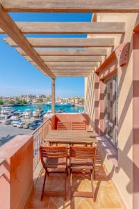 balcón con mesa y sillas de madera en Lovely Sea View 2BR in "Three Corners Ocean View" Marina Abu Tig, El Gouna, en Hurghada