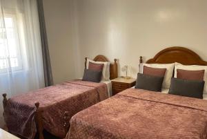 two beds in a hotel room at Moradia da Ilda - Casas de Férias Nazaré in Nazaré