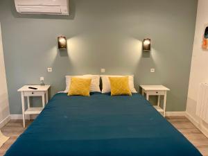 1 dormitorio con 1 cama azul y 2 mesitas de noche en Moulin 1- Appartement Arènes Romaines - Beziers centre - Wifi - Tv connectée en Béziers