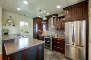 a kitchen with wooden cabinets and a stainless steel refrigerator at Year-round fishing, boating, birding, 1 hr from SF in Walnut Grove
