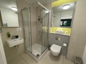 a bathroom with a shower and a toilet and a sink at Quay Apartments Manchester in Manchester