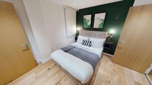 a bedroom with a bed and a dresser at Quay Apartments Manchester in Manchester