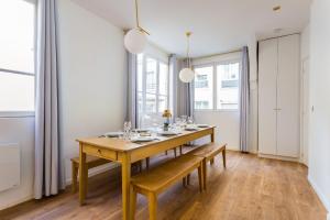 une salle à manger avec une table et des bancs en bois dans l'établissement Appartement8P/Full Equipped/BONNE NOUVELLE/BOURSE, à Paris