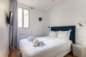 - une chambre avec un grand lit blanc et des serviettes dans l'établissement Appartement8P/Full Equipped/BONNE NOUVELLE/BOURSE, à Paris