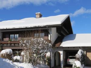 a house with snow on top of it at Ferienwohnung Gouiaa in Bischofswiesen