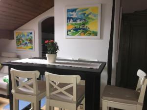 a piano in a room with chairs and a painting at Ferienwohnung Gouiaa in Bischofswiesen