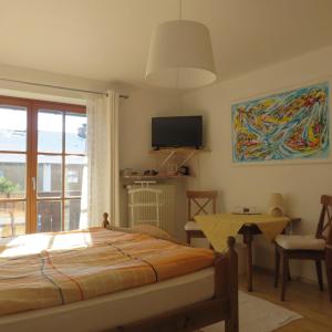 a bedroom with a bed and a table and a tv at Ferienwohnung Gouiaa in Bischofswiesen