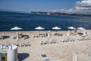 - une plage avec des chaises et des parasols et l'océan dans l'établissement Family Apartment & Outside Pool, à Savudrija