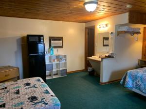 a room with two beds and a bathroom with a sink at Meadow Park on 385 in Bridgeport