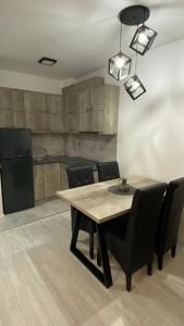 une salle à manger avec une table en bois et des chaises noires dans l'établissement Apartman Petra, à Jagodina