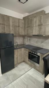a kitchen with a black refrigerator and a sink at Apartman Petra in Jagodina