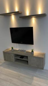 a flat screen tv on a wall in a living room at Apartman Petra in Jagodina