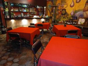 a restaurant with red tables and chairs and a bar at Telpochcalli Hotel & Temazcal in San Juan Teotihuacán