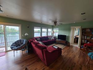 a living room with a red couch and a tv at Year-round fishing, boating, birding, 1 hr from SF in Walnut Grove